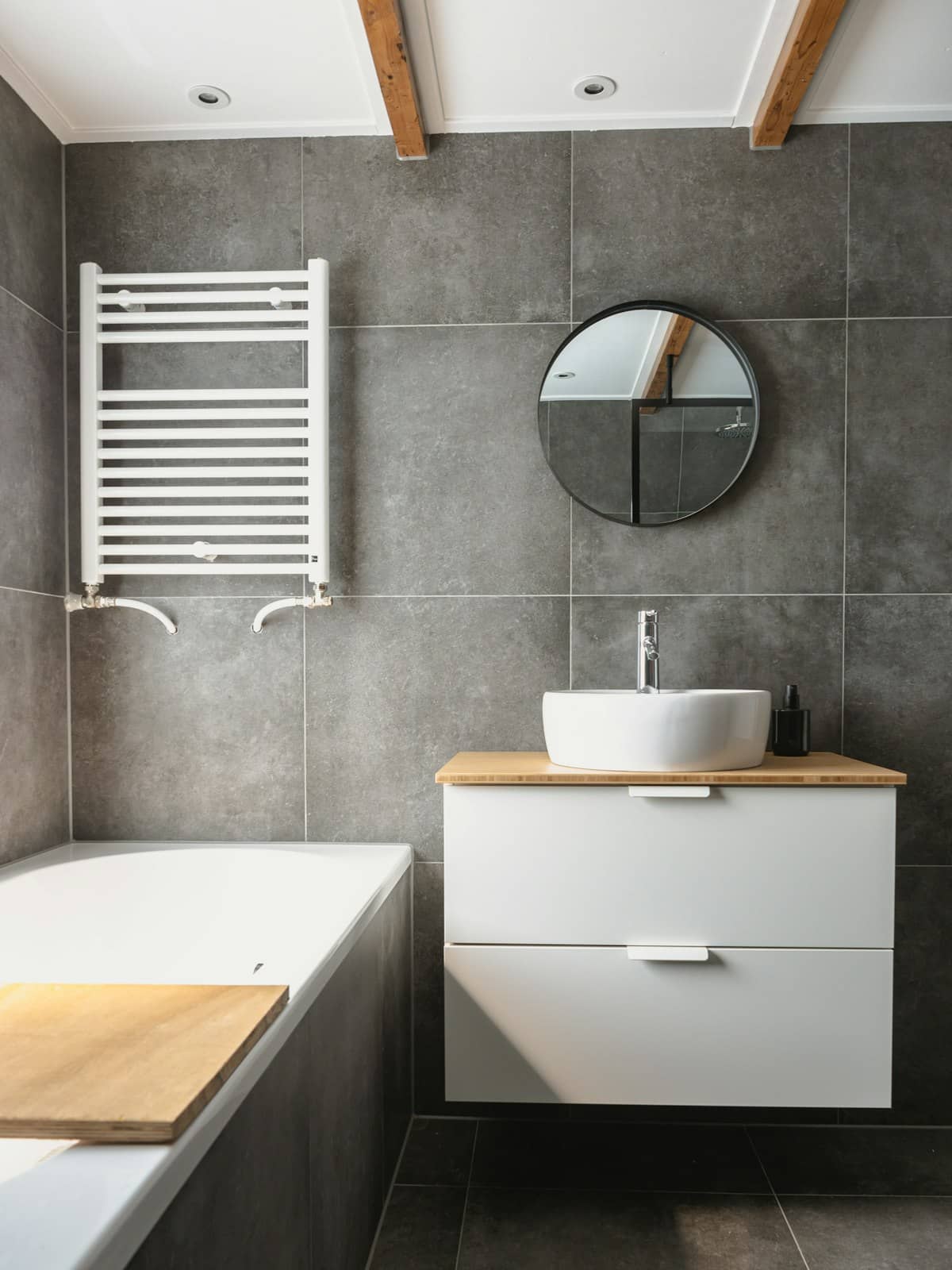 Grey tiled bathroom with a basin and heated towel rail